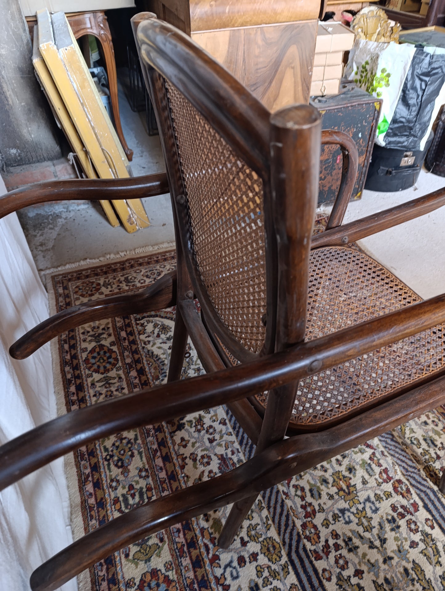 Vue latérale de la chaise porteuse Eug. Vincent, assise cannée et structure bois