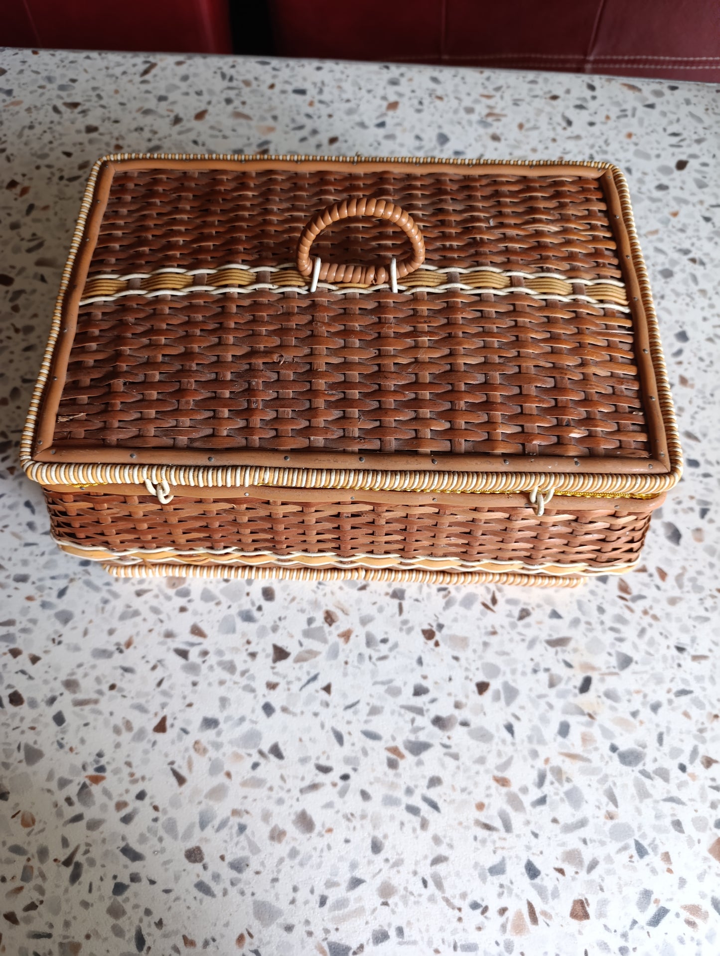Boîte de couture vintage complète, en osier tressé avec intérieur tissu fleuri jaune et blanc.