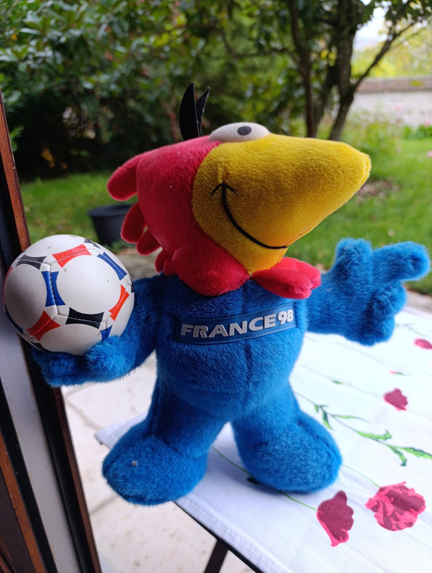 Peluche officielle France 98 représentant la mascotte du Mondial, en position debout tenant un ballon.