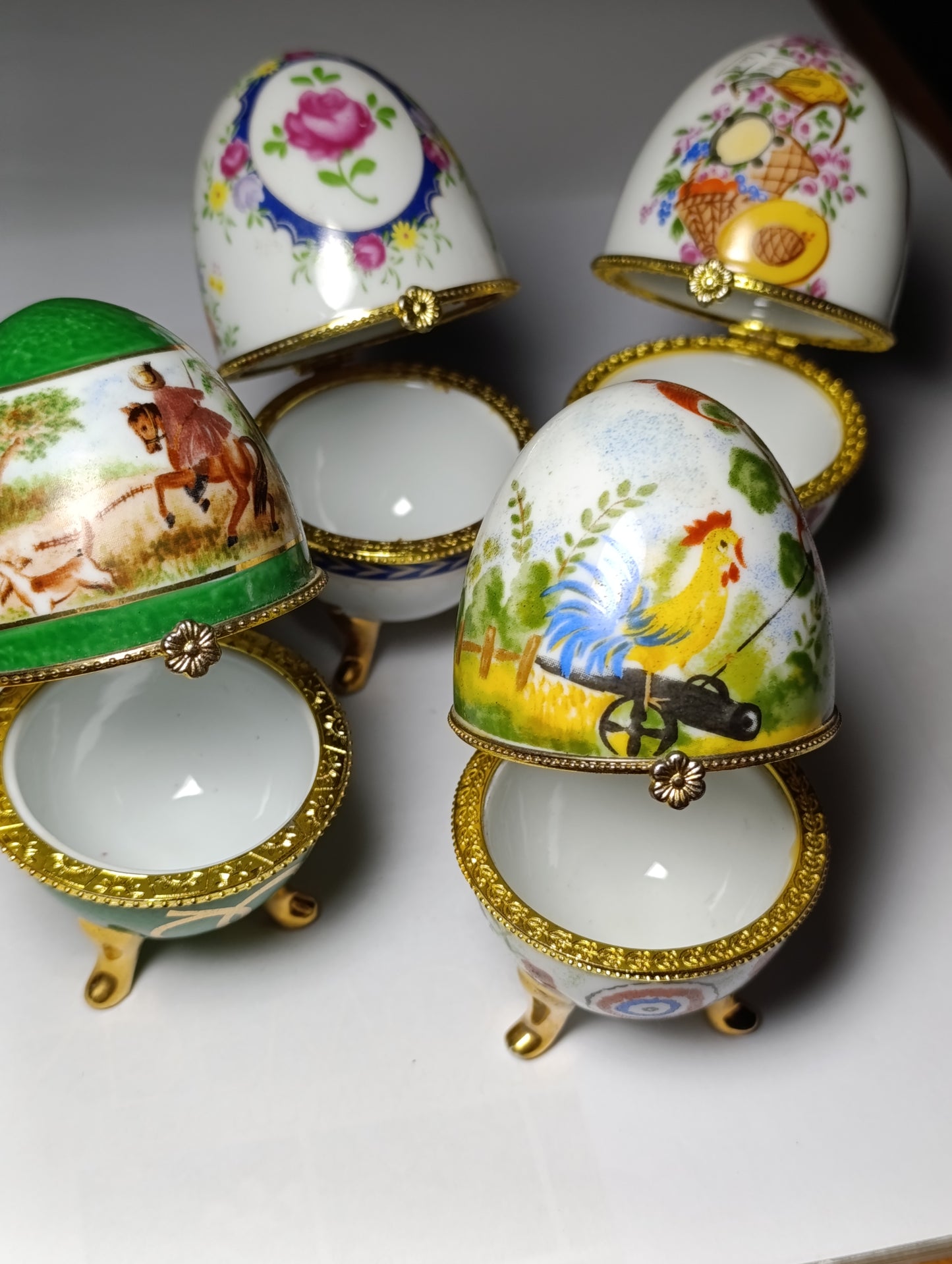 Lot de 4 œufs décoratifs en porcelaine style Fabergé sur pieds dorés
