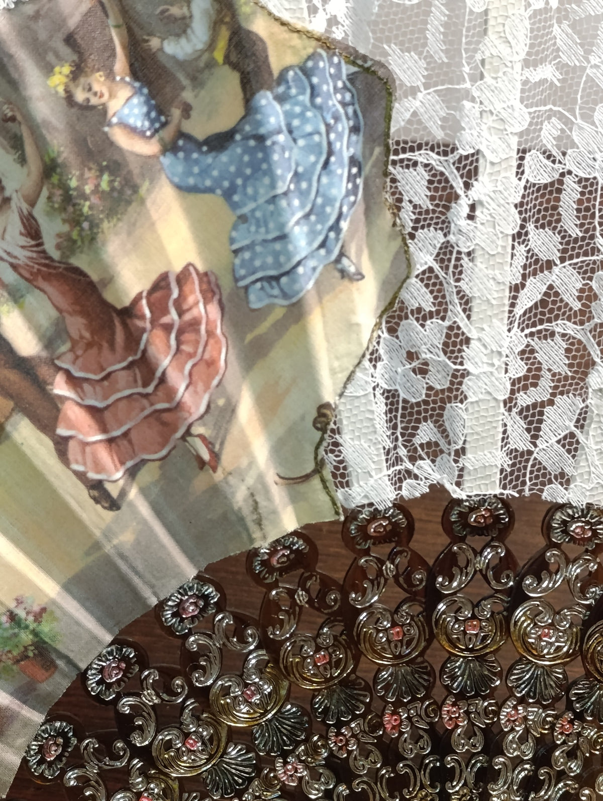 Détail de l’éventail : tissu illustré, dentelle blanche et monture ajourée