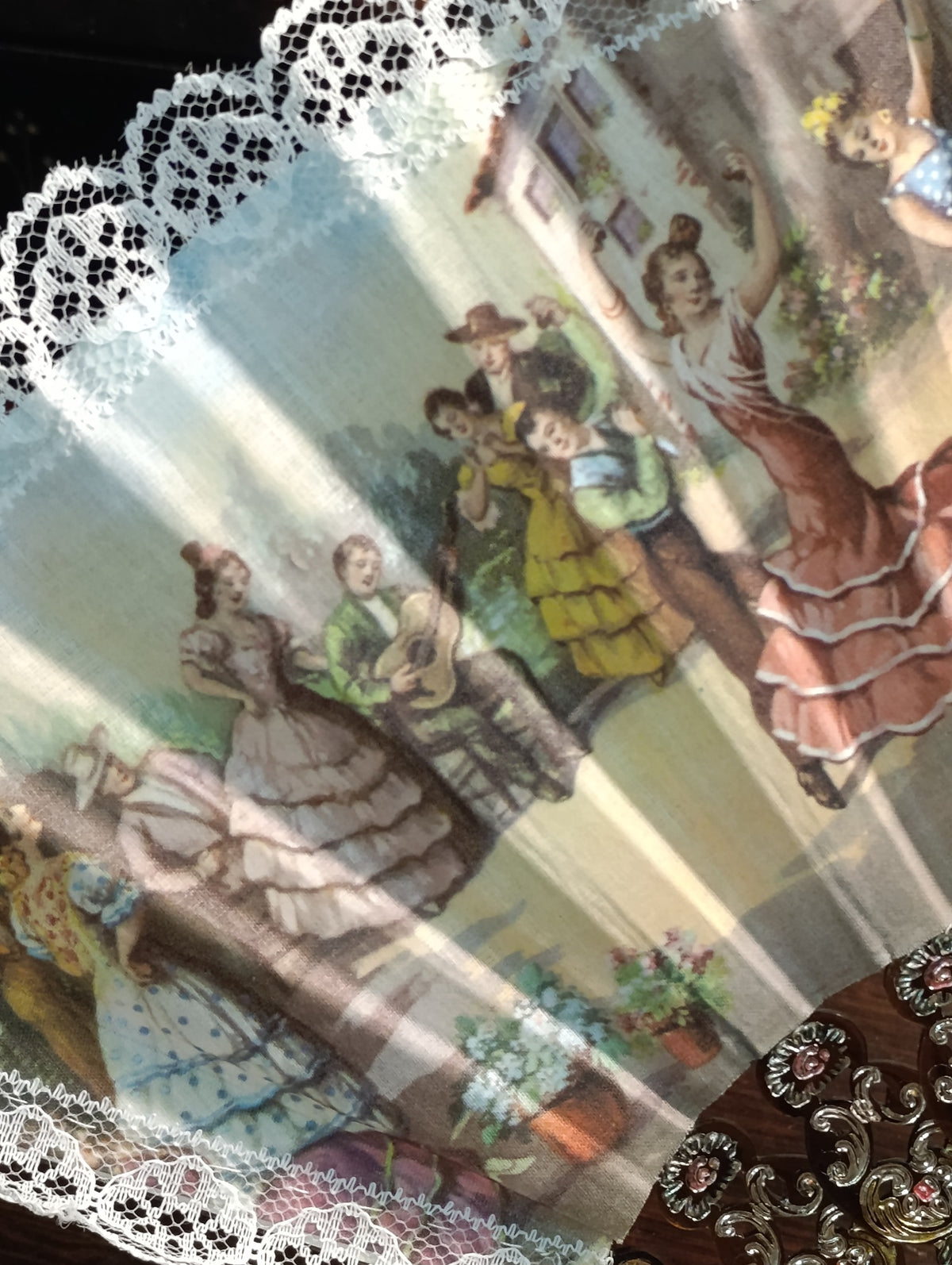 Détail de l’éventail : tissu illustré, dentelle blanche et monture ajourée