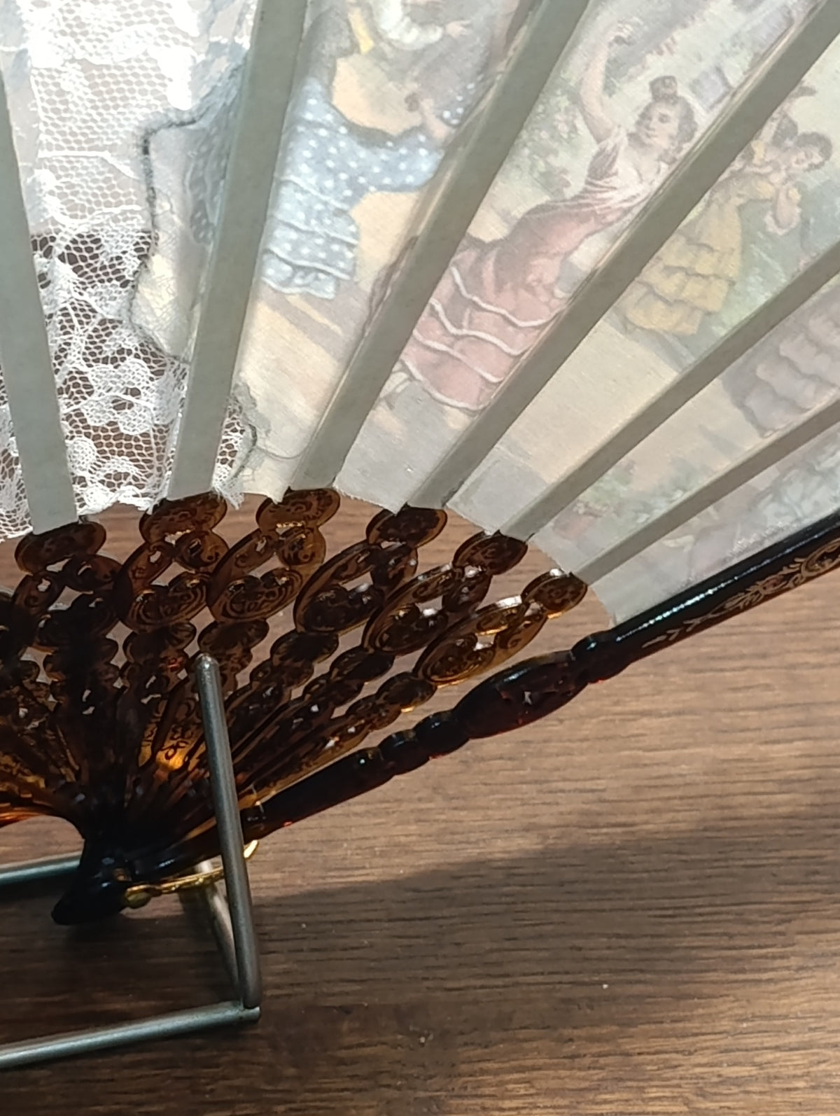 Détail de l’éventail : tissu illustré, dentelle blanche et monture ajourée