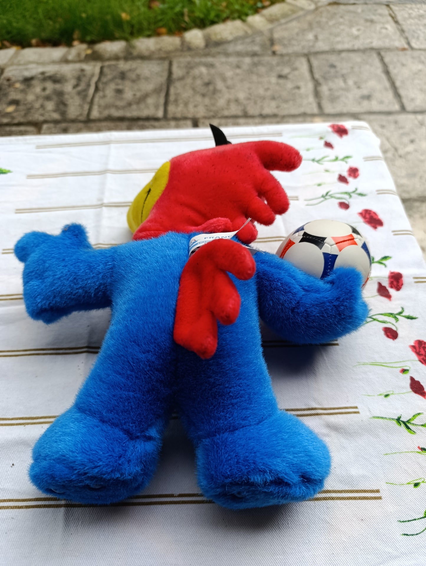 Peluche officielle France 98 représentant la mascotte du Mondial, en position debout tenant un ballon.
