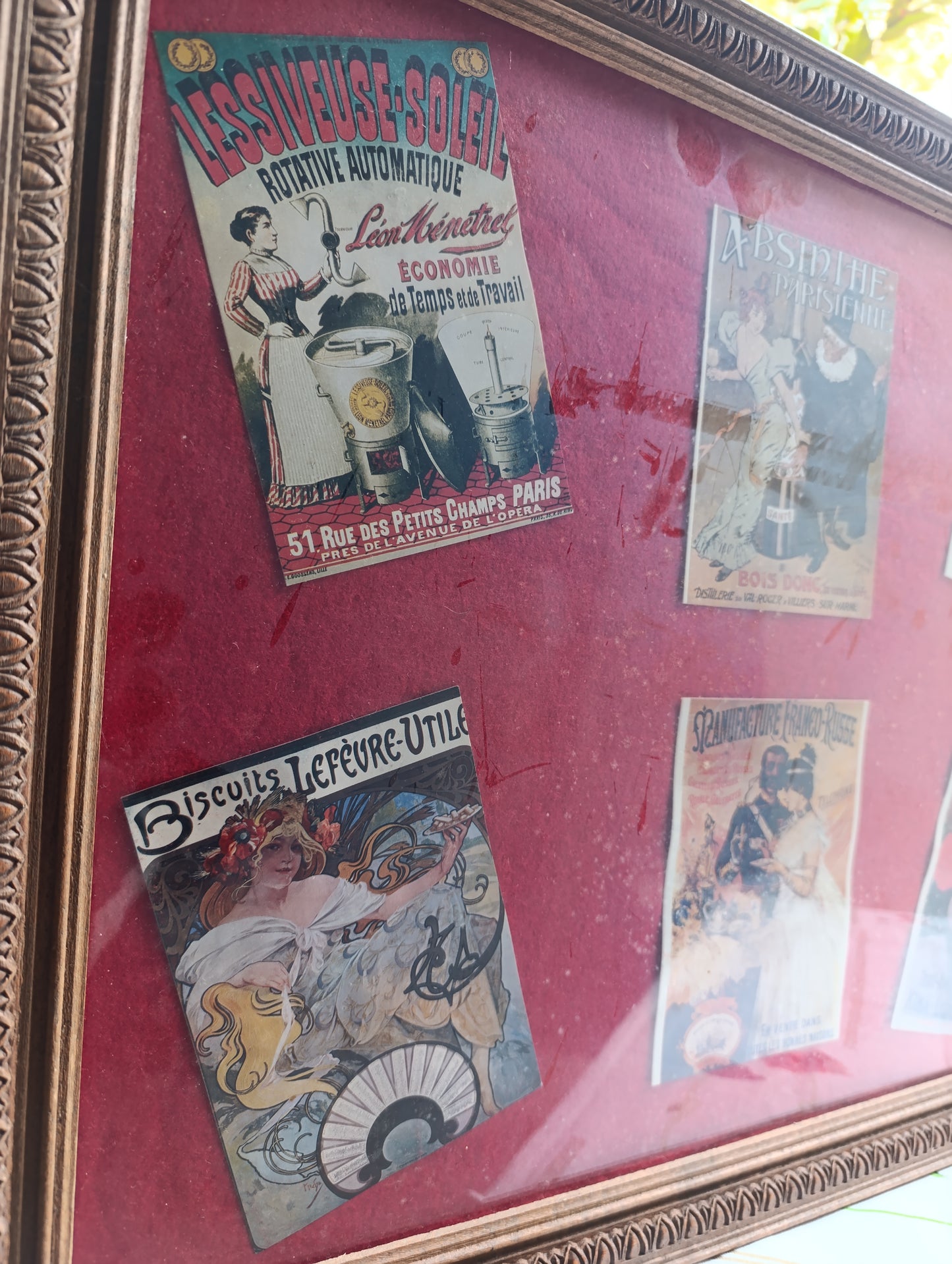 Cadre vintage 46 × 56 cm, poids 2,5 kg, contenant six reproductions d’affiches publicitaires anciennes sur fond rouge bordeaux.