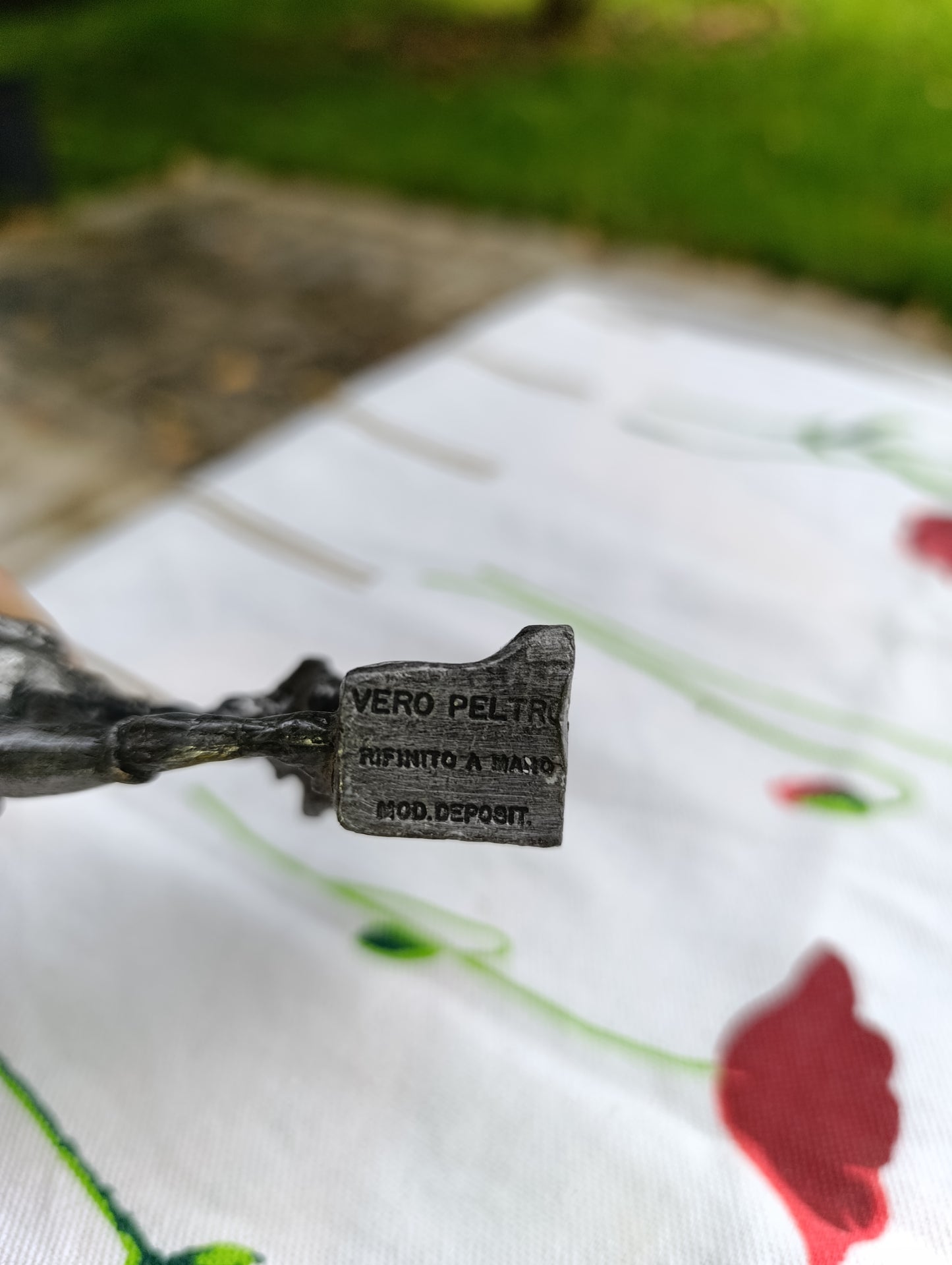 Petite statuette en métal patiné représentant un joueur de football, posant le pied sur un ballon.