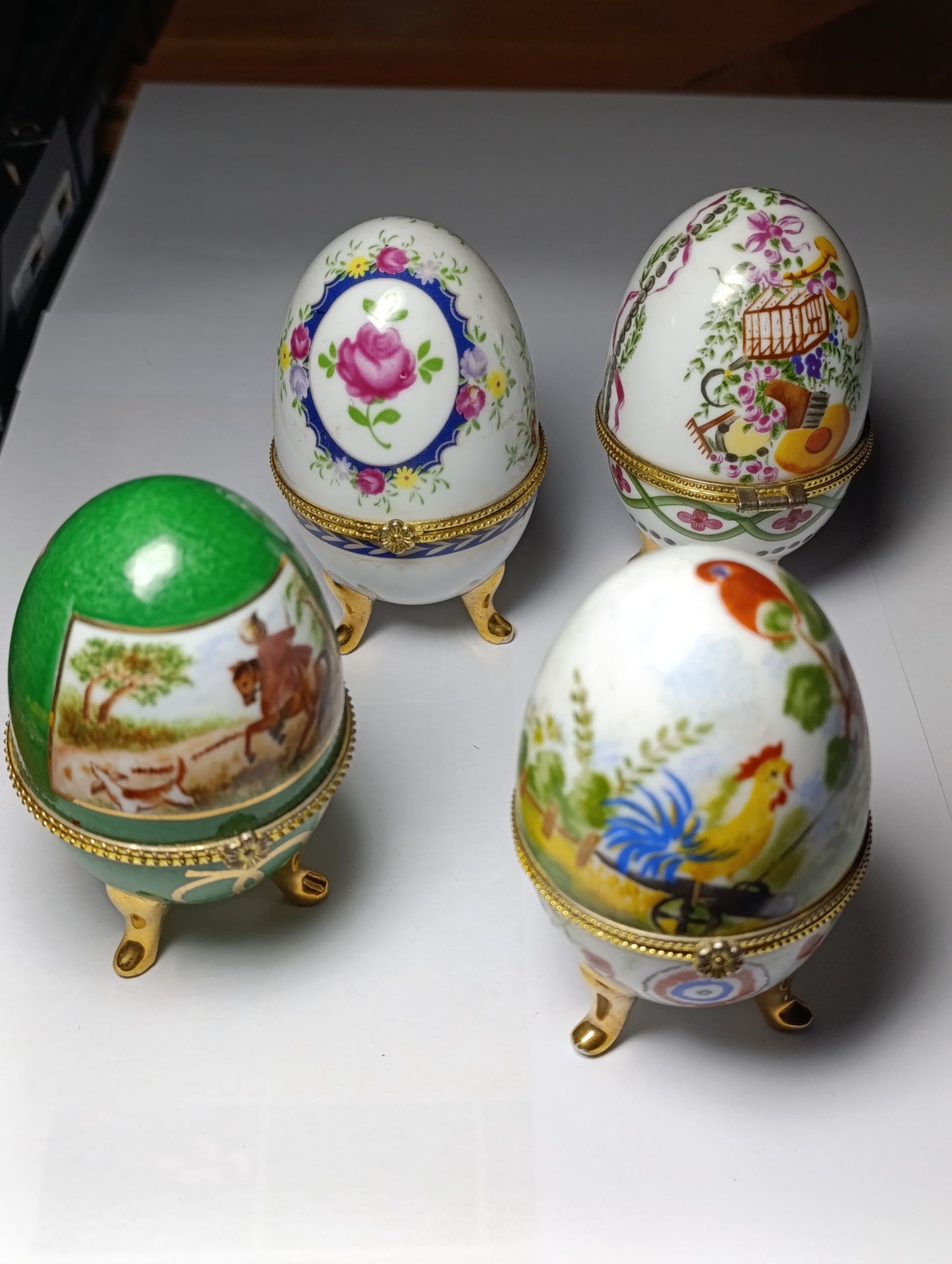 Lot de 4 œufs décoratifs en porcelaine style Fabergé sur pieds dorés