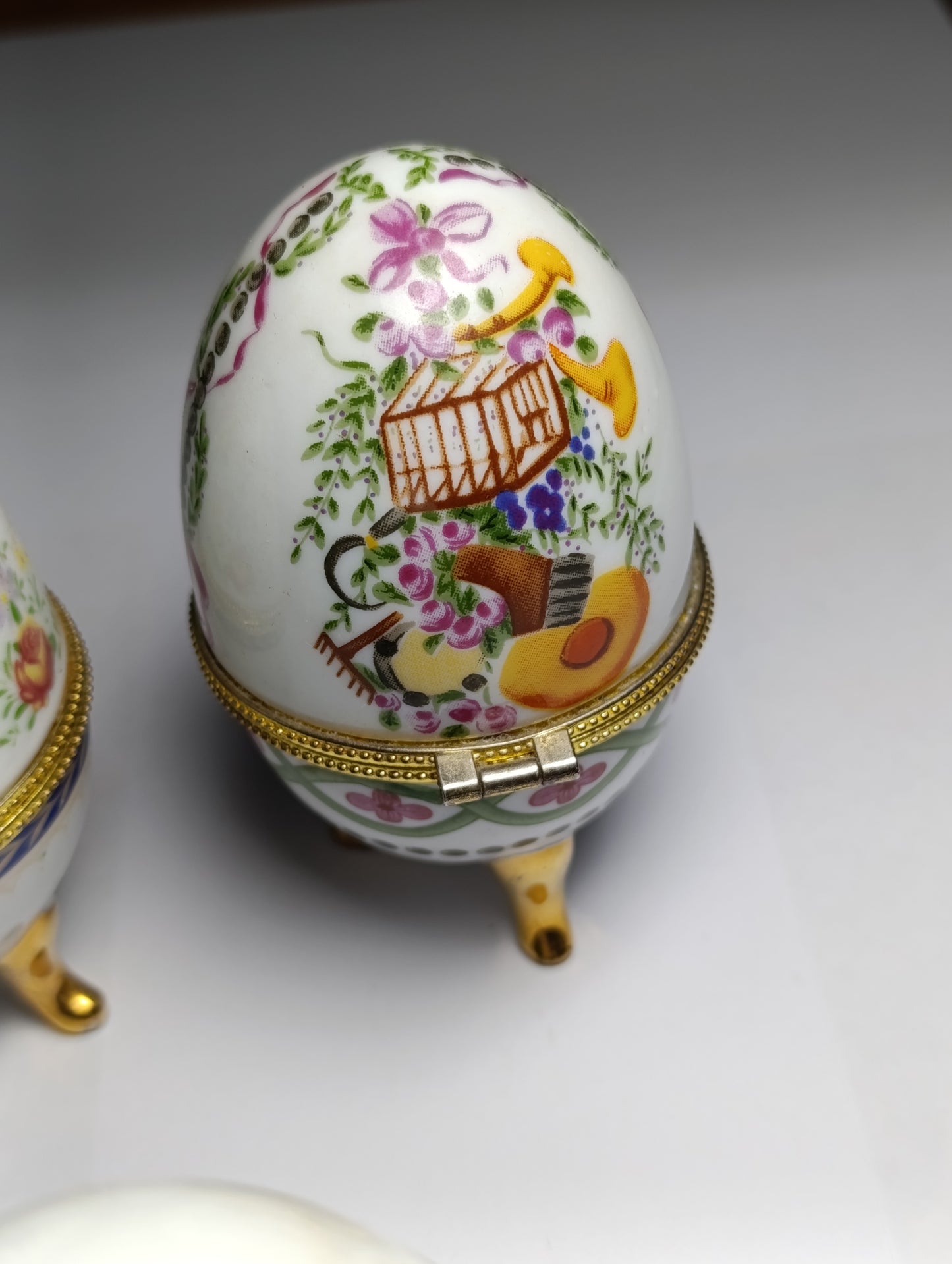 Lot de 4 œufs décoratifs en porcelaine style Fabergé sur pieds dorés