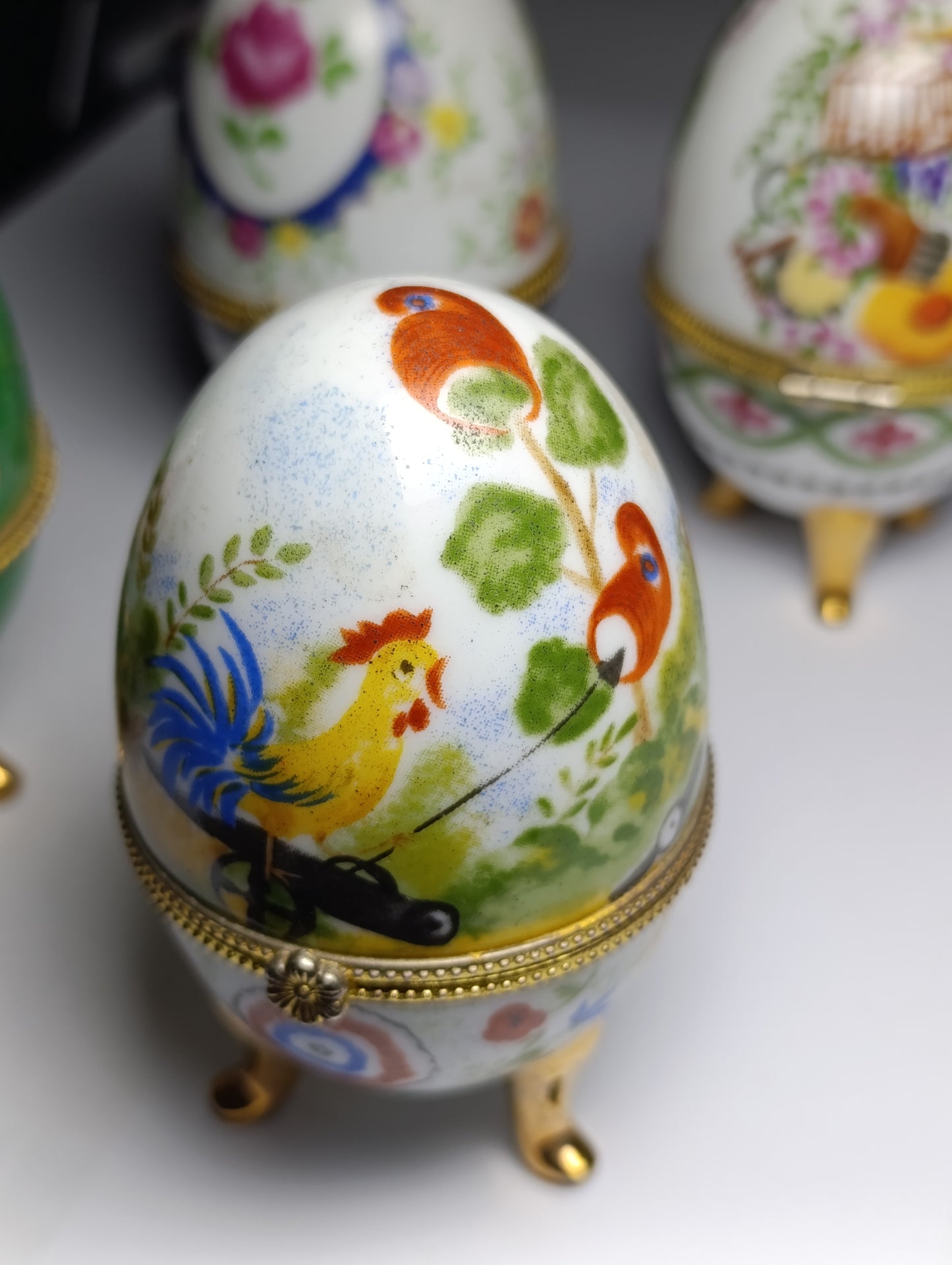 Lot de 4 œufs décoratifs en porcelaine style Fabergé sur pieds dorés