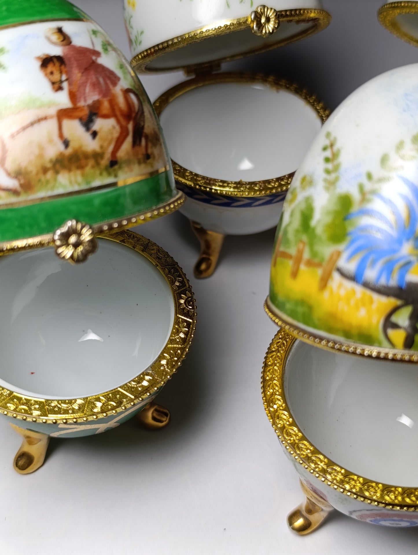 Lot de 4 œufs décoratifs en porcelaine style Fabergé sur pieds dorés