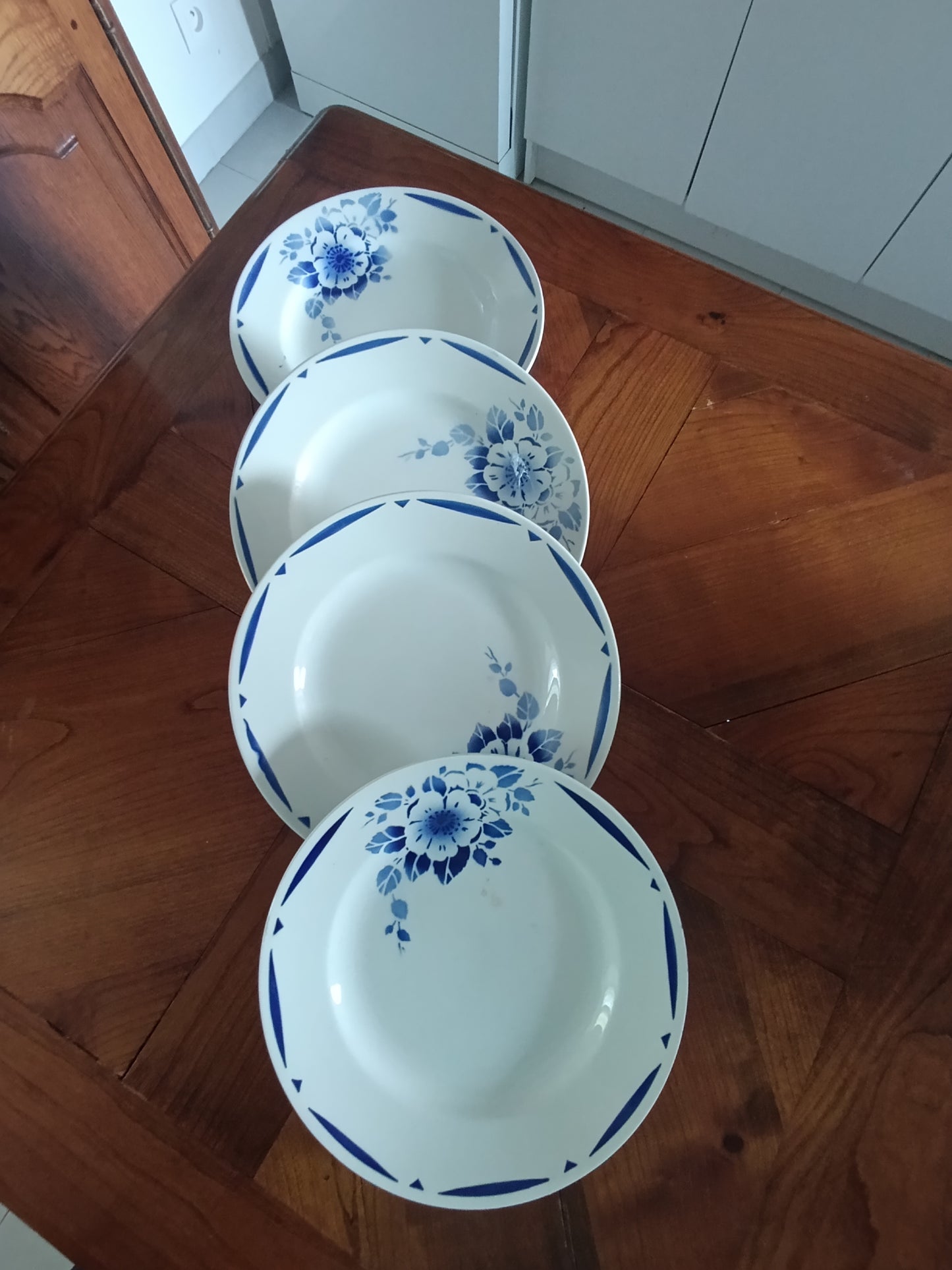 Lot de 4 assiettes creuses anciennes en faïence blanche décor floral bleu.