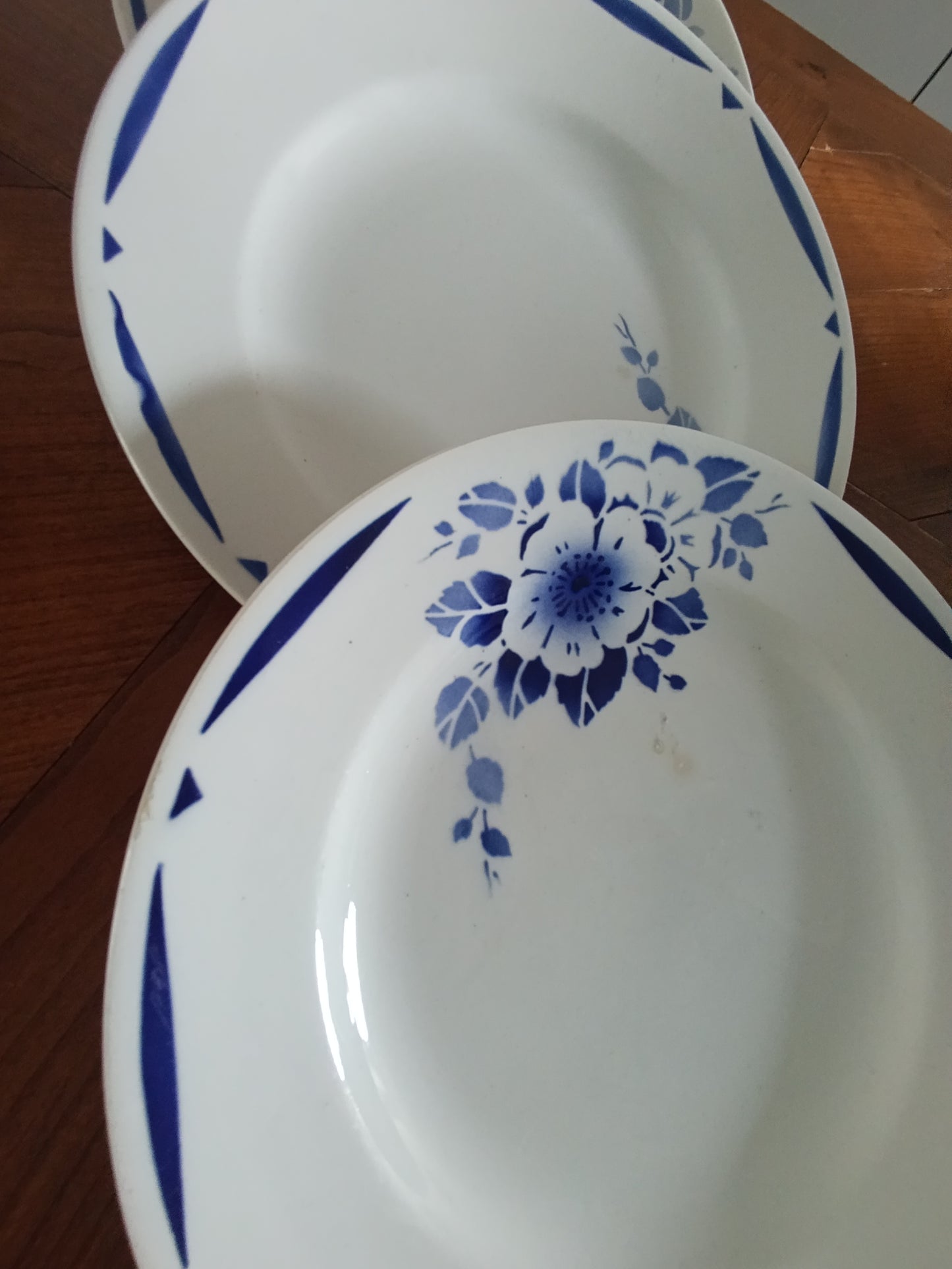 Lot de 4 assiettes creuses anciennes en faïence blanche décor floral bleu.