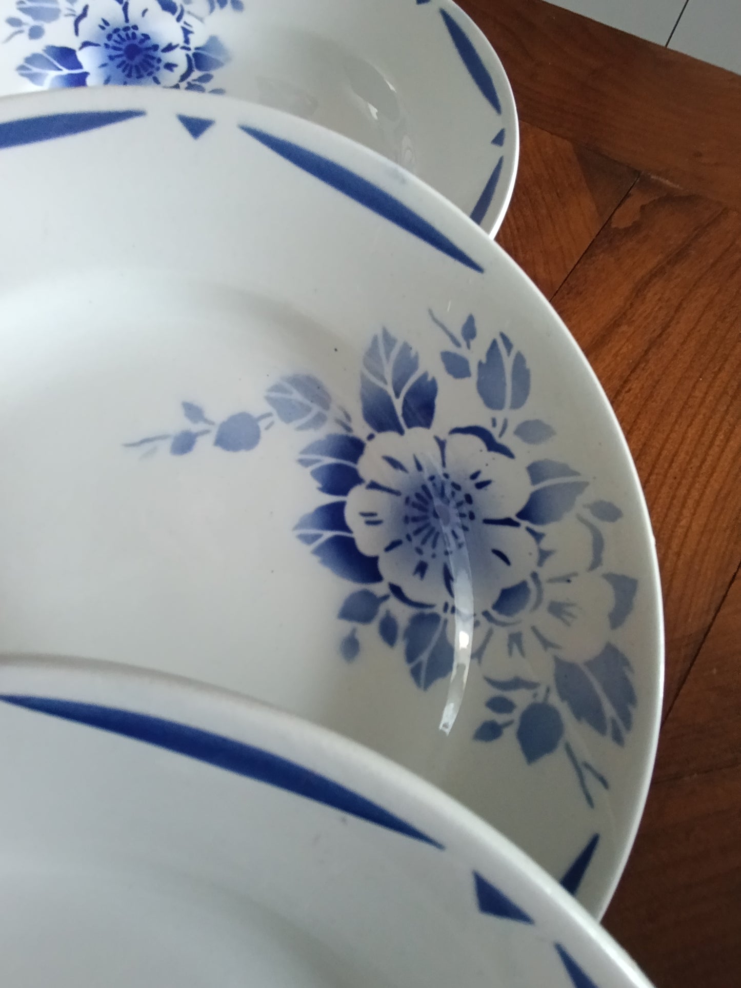 Lot de 4 assiettes creuses anciennes en faïence blanche décor floral bleu.