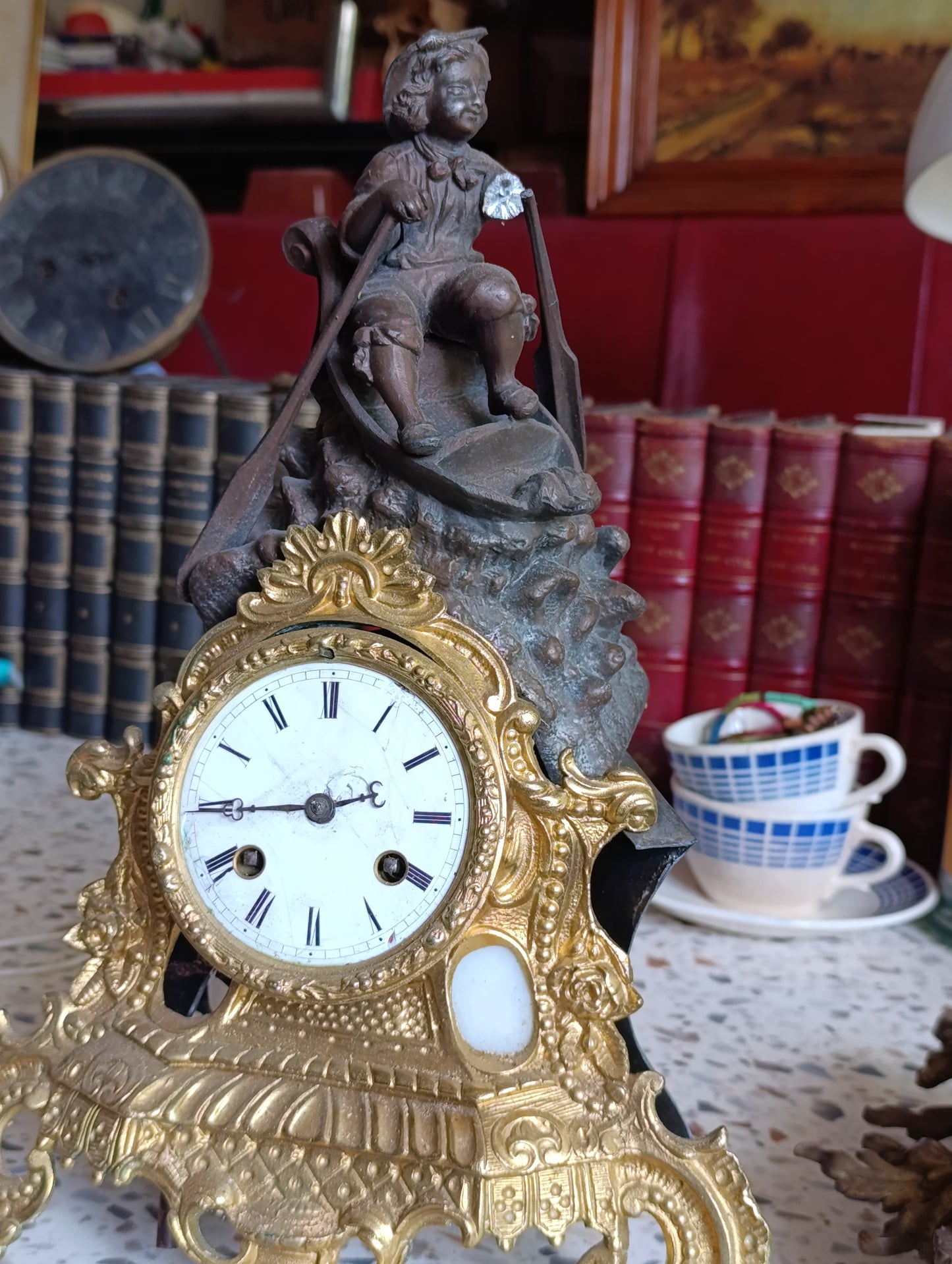 Pendule régule ancienne en régule doré avec sujet enfant en barque – Pour restauration