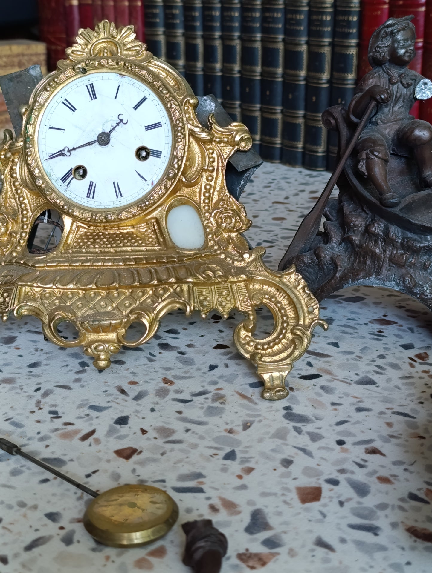 Pendule régule ancienne en régule doré avec sujet enfant en barque – Pour restauration
