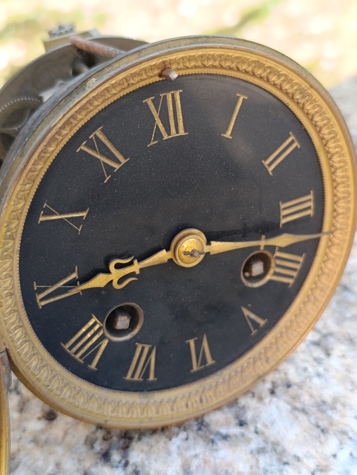 Mouvement d'horloge ancienne avec cadran noir et balancier à restaurer