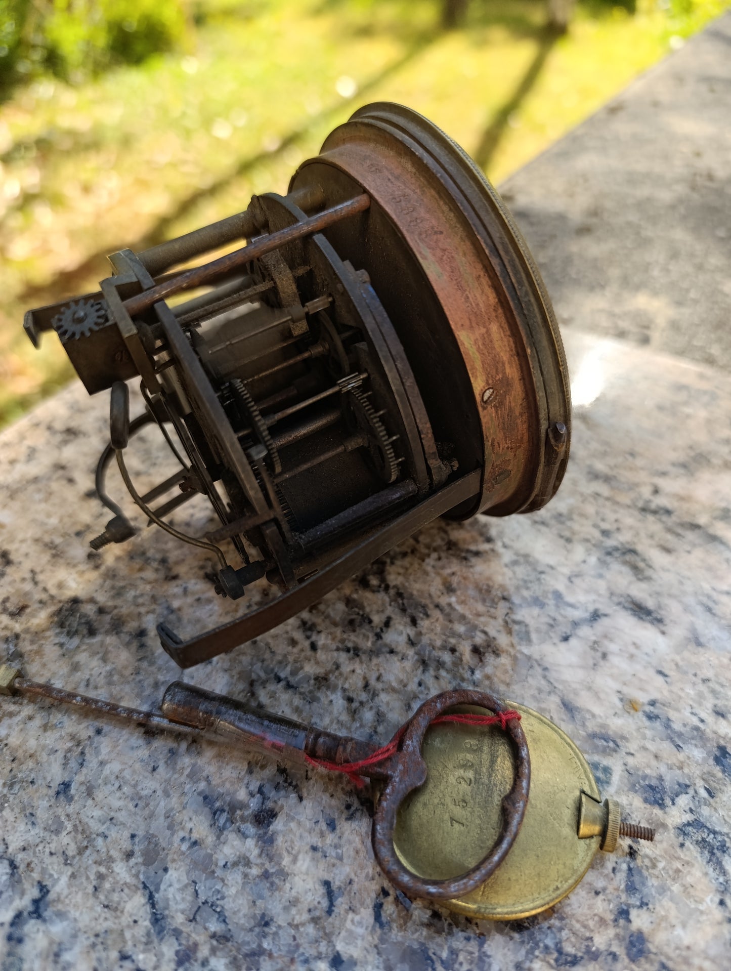 Mouvement d'horloge ancienne avec cadran noir et balancier à restaurer