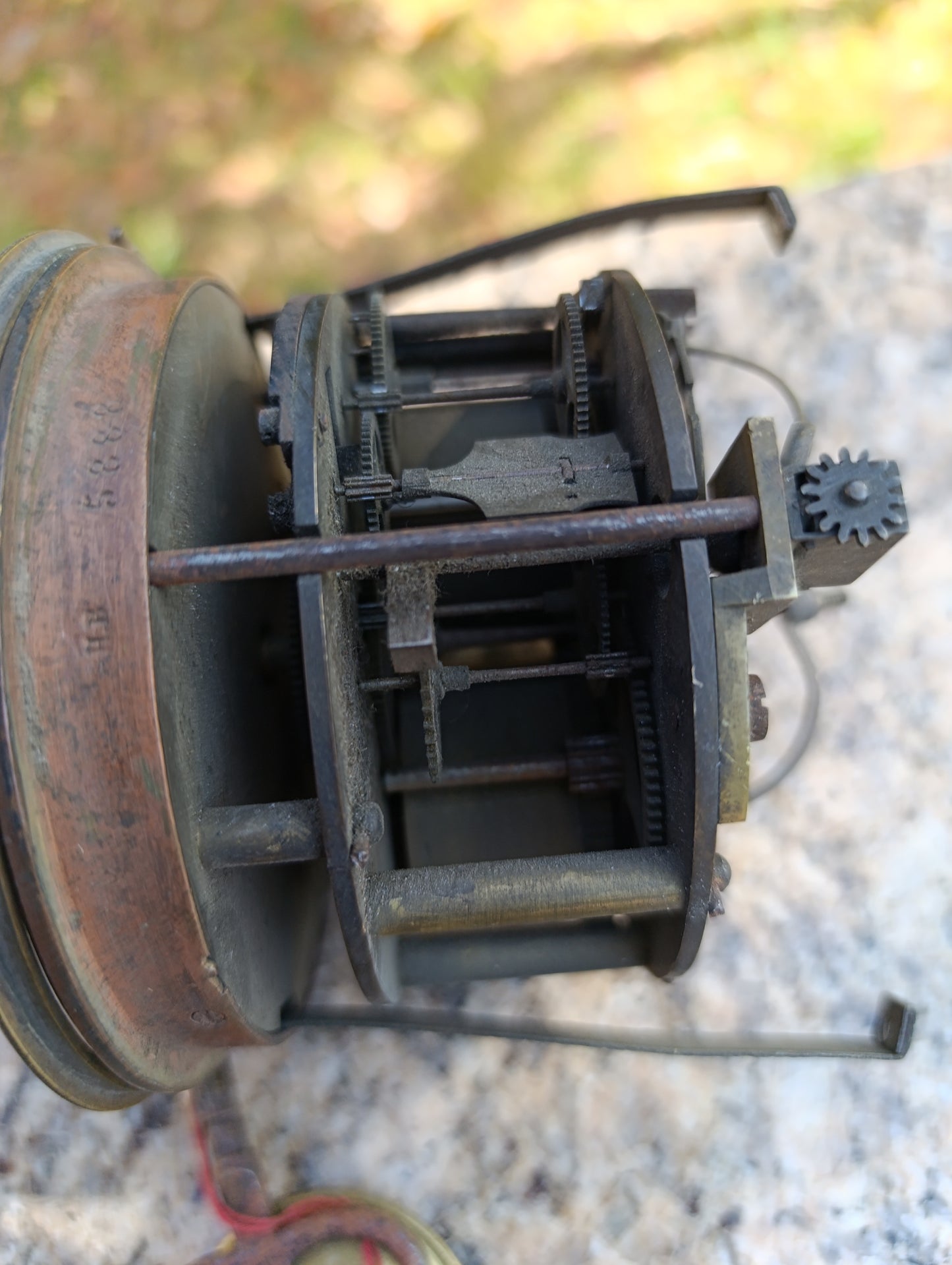 Mouvement d'horloge ancienne avec cadran noir et balancier à restaurer