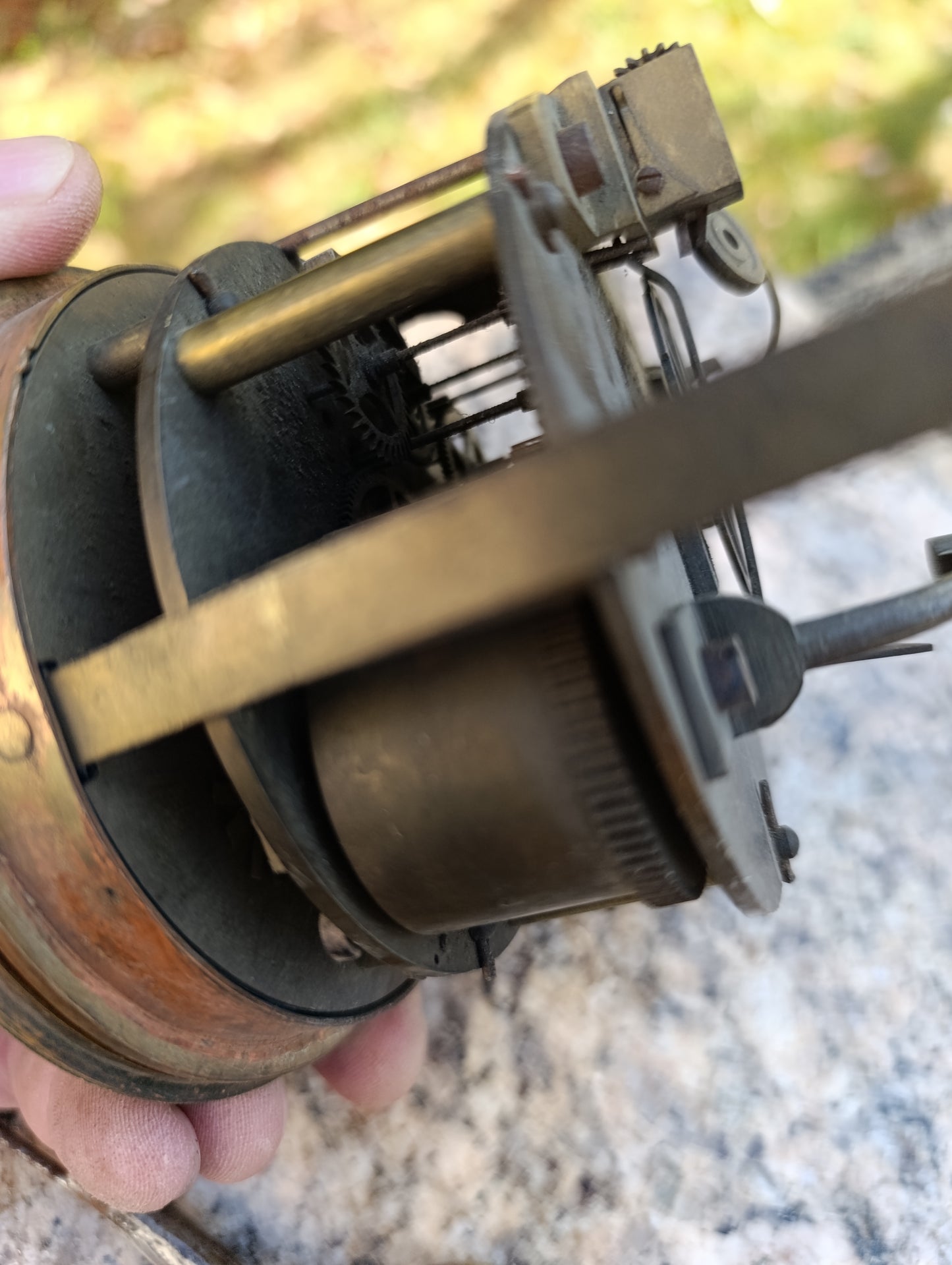 Mouvement d'horloge ancienne avec cadran noir et balancier à restaurer