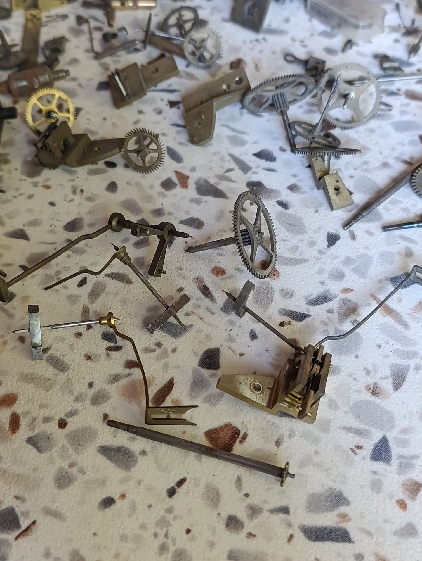 Lot de pièces d’horlogerie ancienne pour restauration – Rouages, barillets, aiguilles, clé, balancier