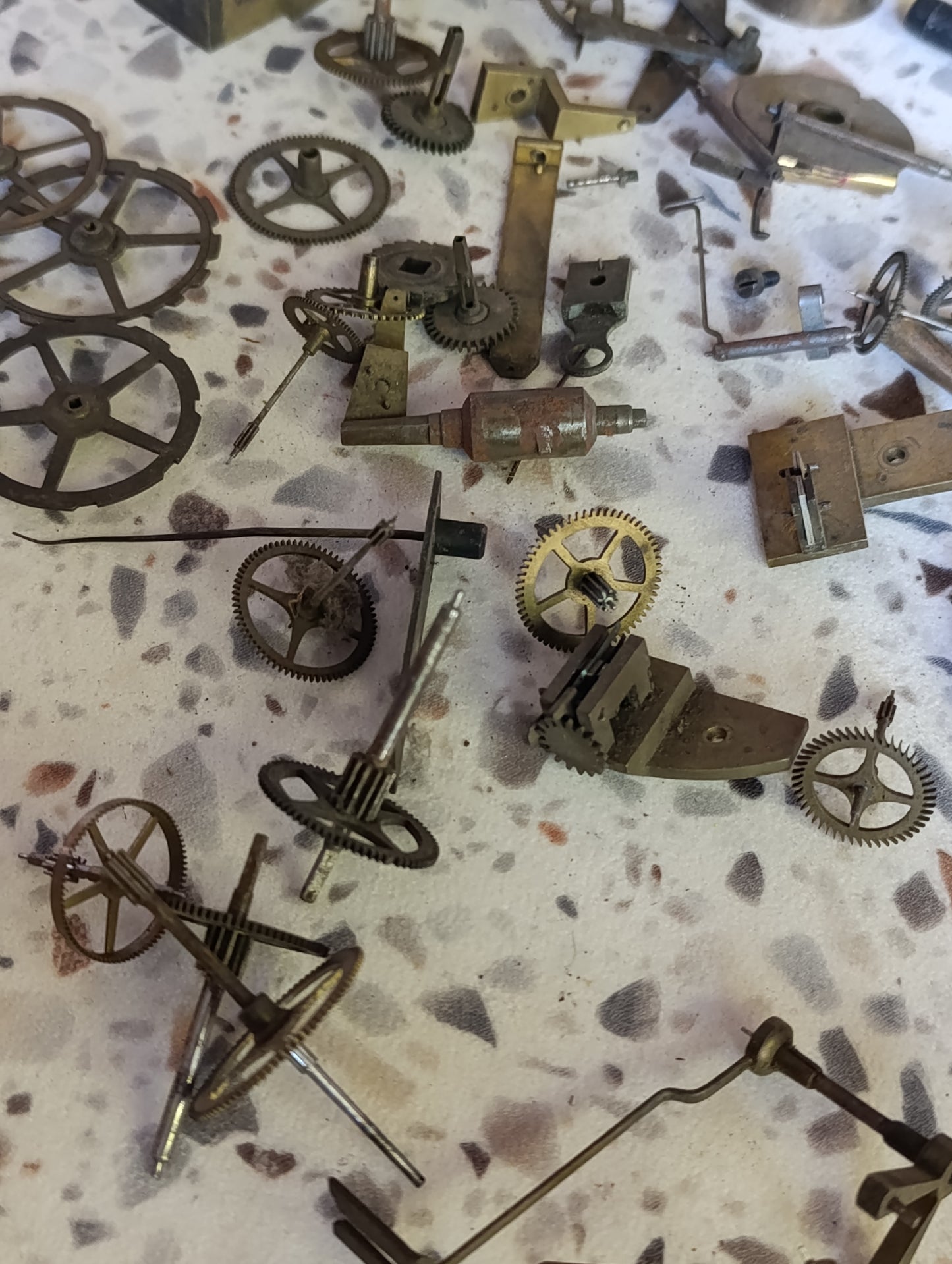 Lot de pièces d’horlogerie ancienne pour restauration – Rouages, barillets, aiguilles, clé, balancier
