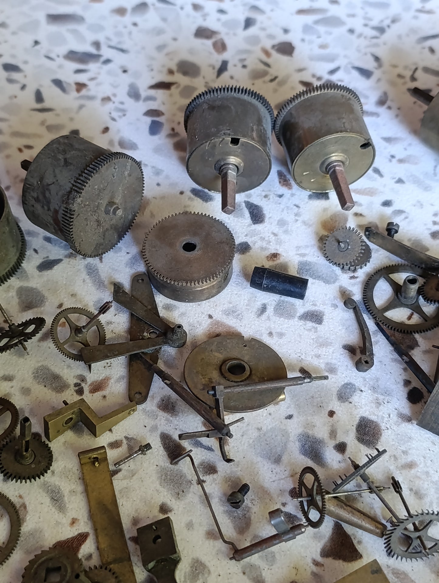 Lot de pièces d’horlogerie ancienne pour restauration – Rouages, barillets, aiguilles, clé, balancier