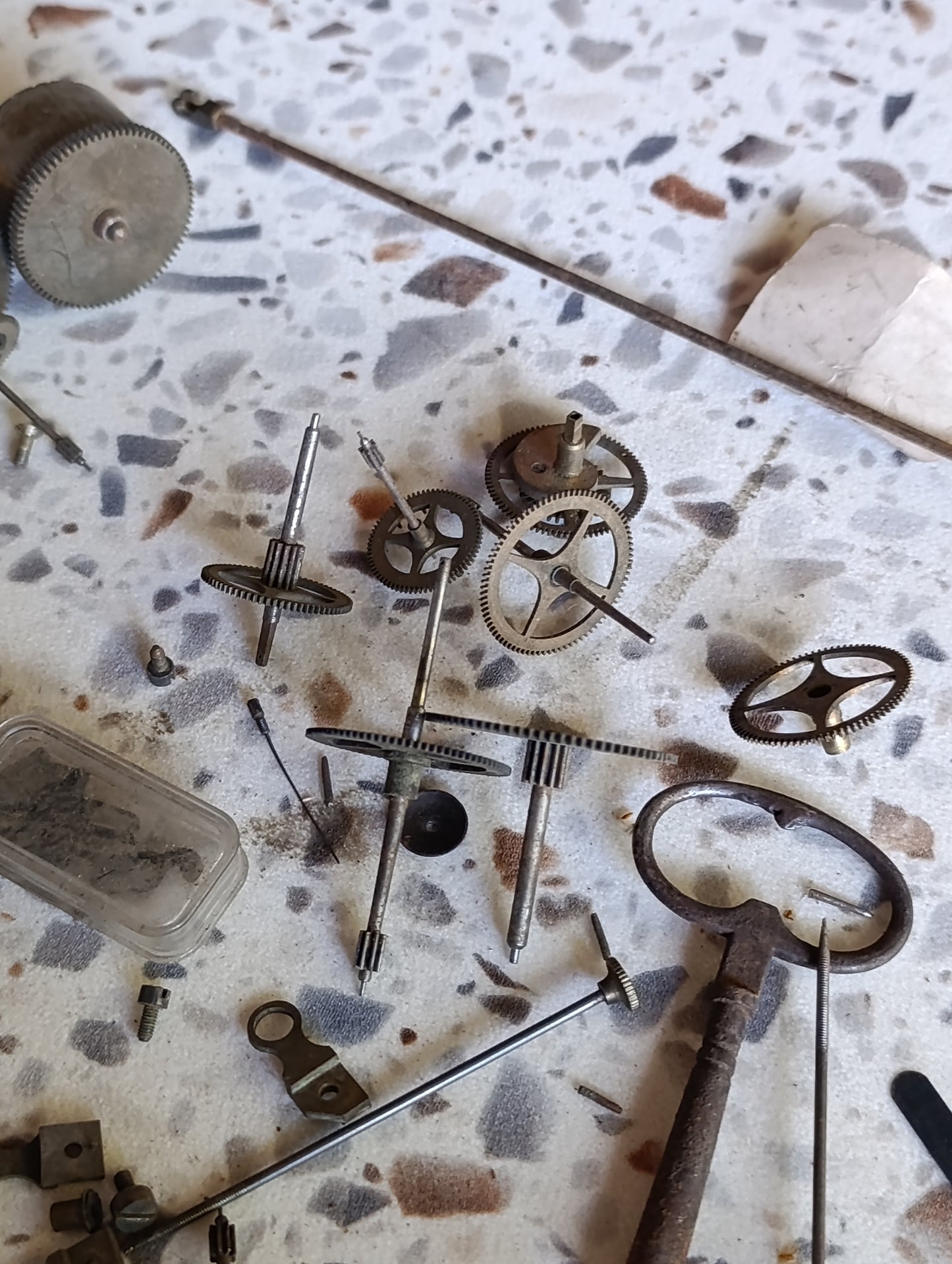 Lot de pièces d’horlogerie ancienne pour restauration – Rouages, barillets, aiguilles, clé, balancier