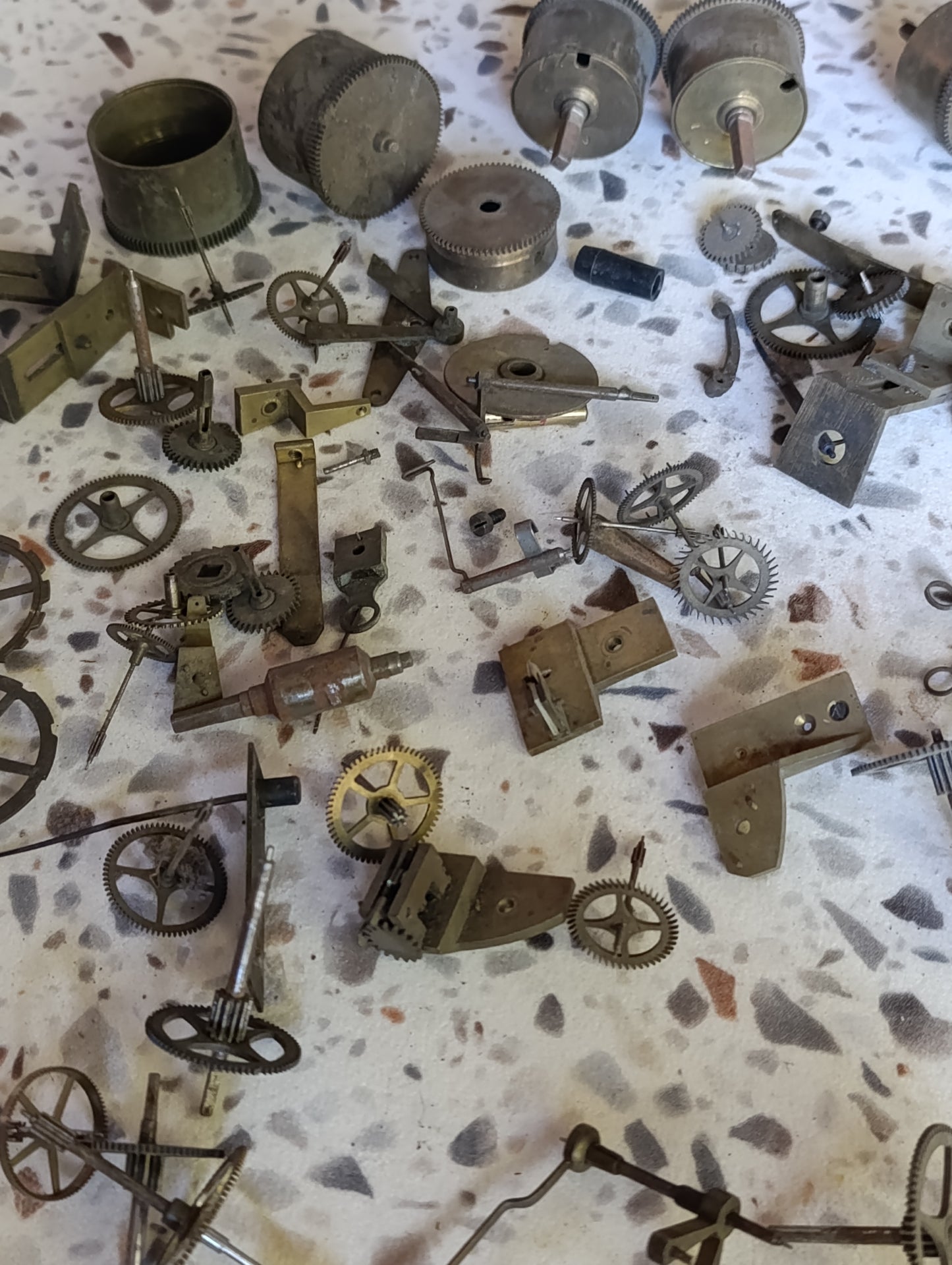 Lot de pièces d’horlogerie ancienne pour restauration – Rouages, barillets, aiguilles, clé, balancier