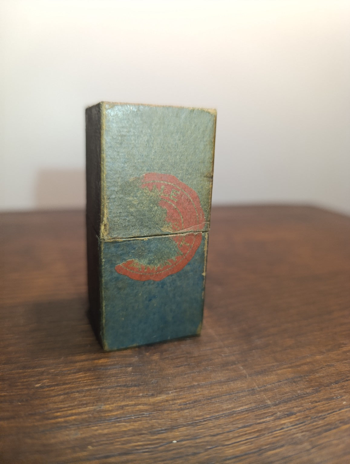 Étui ancien en carton de l’huile Diamant pour montres, fermé, avec traces d’usure et marquage rouge effacé.