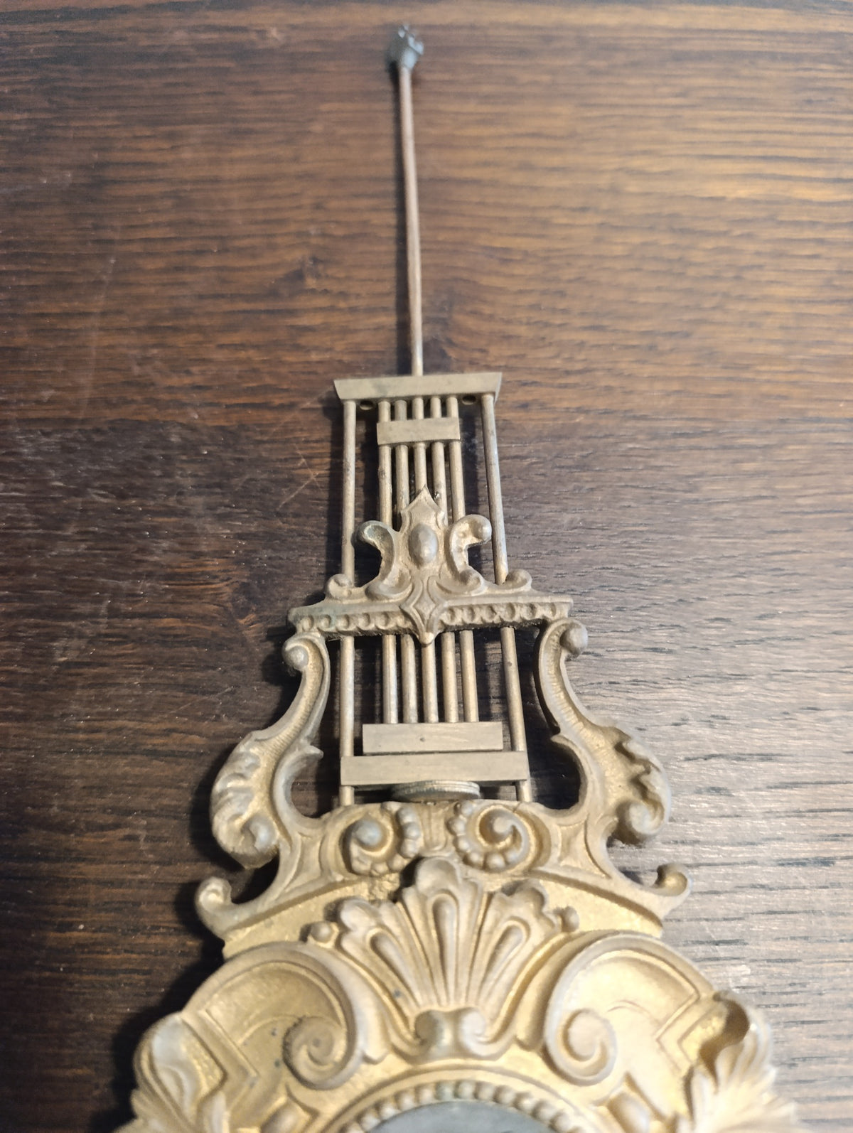 Balancier ancien de pendule à décor de lyre et volutes dorées