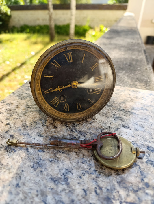 Mouvement d'horloge ancienne avec cadran noir et balancier à restaurer
