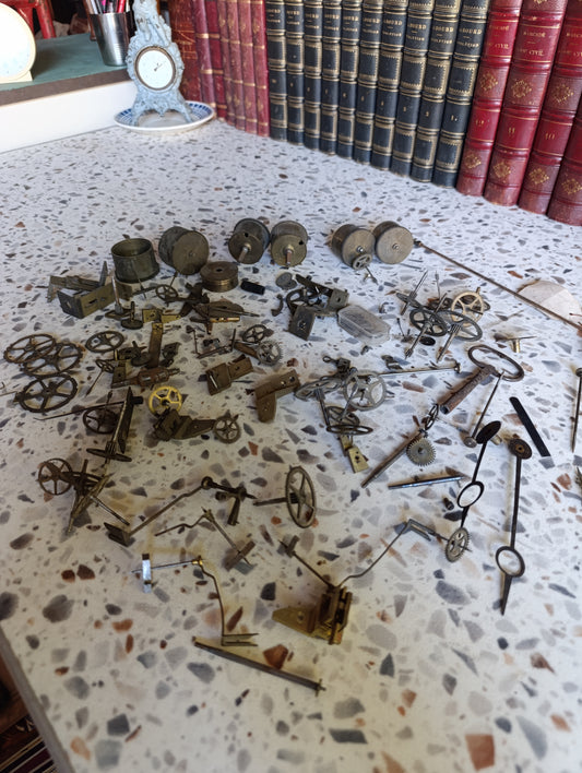 Lot de pièces d’horlogerie ancienne pour restauration – Rouages, barillets, aiguilles, clé, balancier
