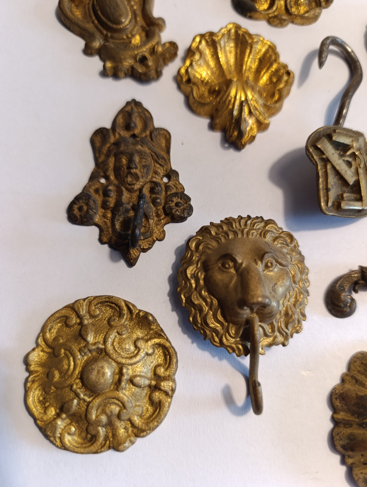 Lot de 10 ornements anciens en métal doré – lions, rosaces et crochets